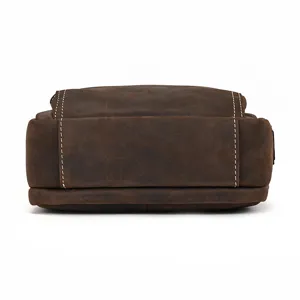 Close-up detail of the bottom and sturdy stitching of a vintage brown leather shoulder bag.