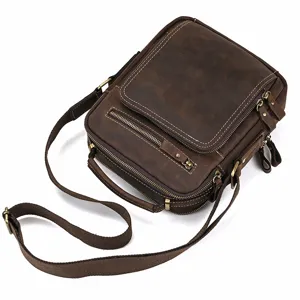 Vintage brown leather shoulder bag detail showing multi-zipper pocket, hardware and strap.