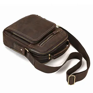 Detail view of vintage genuine leather messenger bag with multiple zipper pockets.