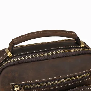 Close-up detail of vintage brown leather bag handle and exquisite metal zippers.