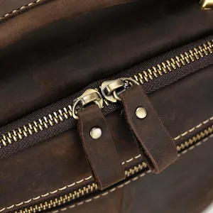 Close up detail view of vintage genuine leather bag featuring durable metal zippers.