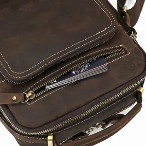 Vintage genuine leather crossbody bag detail shot, showing zipper pocket and fine stitching.
