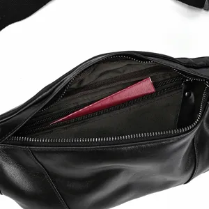 Close-up detail of black leather men's chest bag interior with metal zipper and spacious pockets.