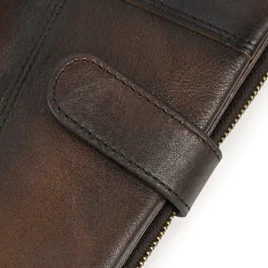 Vintage distressed genuine leather wallet detail closeup showcasing fine stitching and zipper.