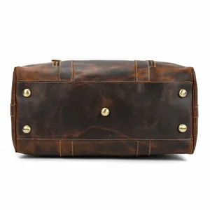 Vista detallada del fondo de una bolsa de viaje de cuero vintage con pies de metal.