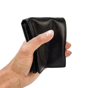 Vista detallada de la cartera de cuero negro que muestra una textura suave y diseño compacto.
