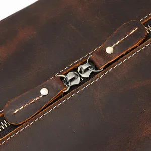 Primer plano de la bolsa de viaje vintage de cuero crazy horse con cremalleras metálicas.