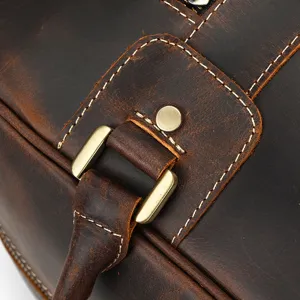 Primer plano de los herrajes metálicos y costuras de bolso de viaje de cuero vintage.