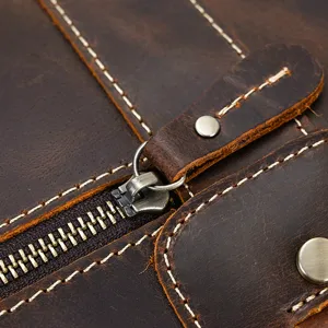Primer plano detallado del bolso de cuero estilo vintage con cremallera y costuras.