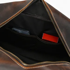Detalle interior bolsa de viaje de cuero vintage, con bolsillos espaciosos y costuras duraderas.