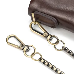 Detailed view of retro brown genuine leather wallet with vintage bronze metal chain and clasp.