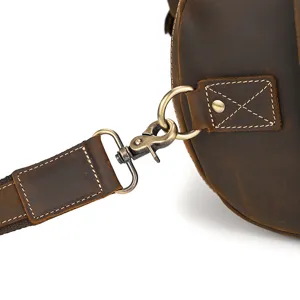 Detalle de los herrajes metálicos y la correa de la bolsa de viaje de cuero vintage.