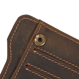 Detalle de cartera de cuero vintage con costuras exquisitas y botón a presión de bronce de cerca