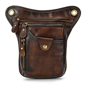Genuine leather drop leg bag detail showing vintage brown distressed finish and metal zippers.