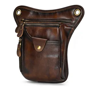 Detail view of vintage brown genuine leather drop leg bag featuring multi-zipper pockets and hardware.