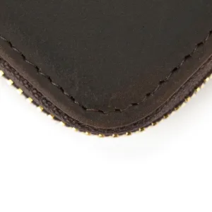 Gedetailleerd overzicht van de bruine lederen portemonneehoek met nette stiksels en rits.