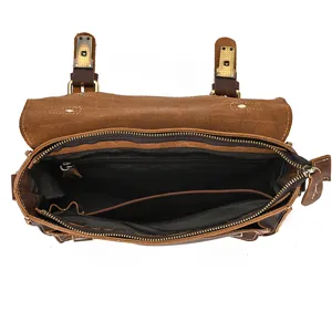Vintage brown leather messenger bag interior detail showing compartments and zipper pocket.