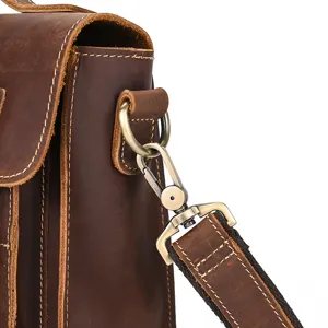 Close-up detail shot of retro brown crazy horse leather bag strap hardware and metal buckle.