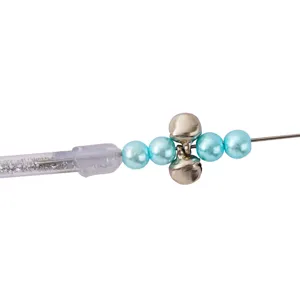 Primer plano del detalle del juguete para gatos con perlas azules y pequeñas campanitas.