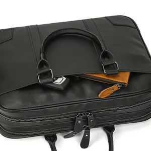 Detailed view of black leather business briefcase showing premium cowhide texture and double zippers.