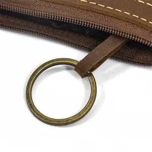 Close up detail of vintage brown crazy horse leather coin purse zipper and metal keyring.