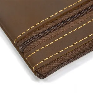 Close-up detail of retro crazy horse leather coin purse with multiple metal zippers and stitching.