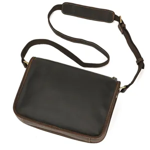 Detailed view of vintage leather messenger bag, showing texture and durable metal hardware.