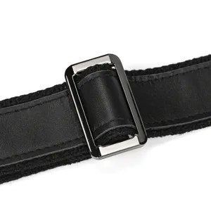 Close up view of the black leather bag adjustable strap and metal buckle detail.
