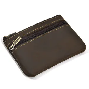 Close-up detail of vintage brown leather coin purse showing zipper and fine stitching.