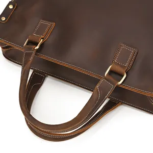 Primo piano dettagliato della maniglia della borsa da uomo in pelle retrò con cuciture.