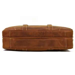 Close-up detail of brown leather business briefcase, highlighting neat stitching and texture.