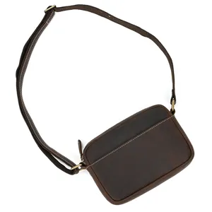 Close-up detail of the vintage leather shoulder bag showing stitching and metal hardware.