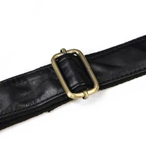 Dettaglio cinturino borsa in pelle con fibbia in metallo ottone antico, stile vintage.