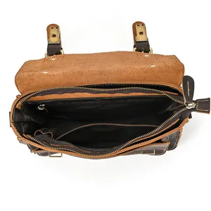 Detailed view of the vintage leather shoulder bag interior, showing compartments and zippers.