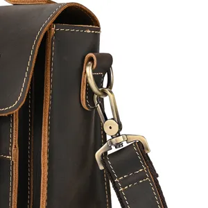Detailed view of vintage crazy horse leather shoulder bag strap metal hook and solid stitching.