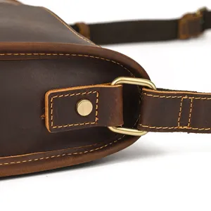Close-up detail of vintage crazy horse leather men shoulder bag metal hardware buckle strap.