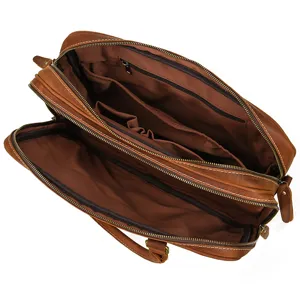 Interior detail view of brown leather briefcase, showing multiple organized compartments and zippers.