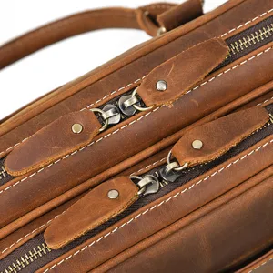 Detailed view of genuine leather men briefcase zipper craftsmanship and premium cowhide texture.