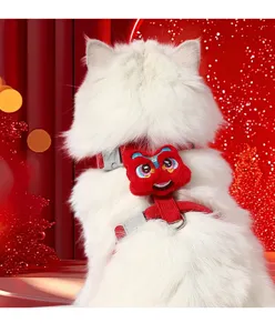 Close-up detail of the red Chinese lion dance pet harness featuring cute plush decoration.