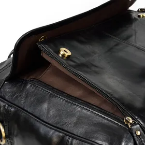 Primo piano della tasca interna con zip e della fibbia magnetica in metallo della borsa.