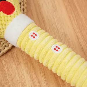 Primo piano di un giocattolo da masticare per cani in peluche strutturato giallo con bottoni.