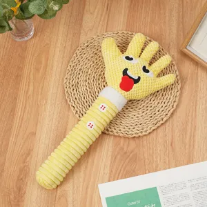 Primo piano di gioco per cani in peluche a forma di mano gialla con tessuto testurizzato.