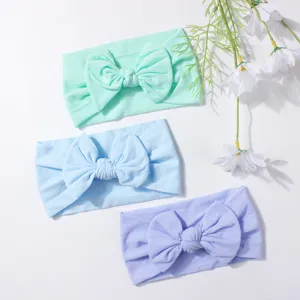 Detailed view of soft nylon baby headbands with large bows in three pastel colors