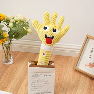Dettaglio di un divertente giocattolo da masticare per cani in peluche giallo con fischietto e viso.
