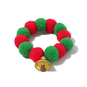 Festive Christmas pet collar featuring red and green pom poms and a cute golden bell