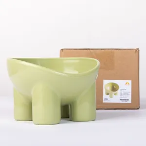 Green ceramic pet bowl with elephant legs, neck-protecting tilted design for cats and dogs.