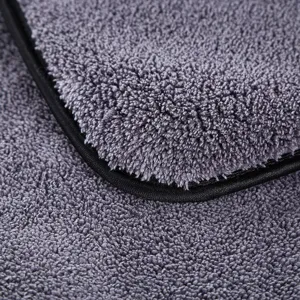 Thick microfiber car wash towel detail shot, showing ultra soft dense fleece and black edge binding.