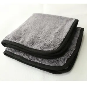 Close-up detail of grey microfiber cleaning towel with black border, soft absorbent fabric.