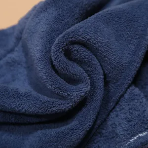 Dark blue microfiber dry hair towel close-up, ultra absorbent soft coral fleece fabric.