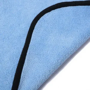 Detalle de toalla de microfibra para mascotas con tela absorbente y borde negro.